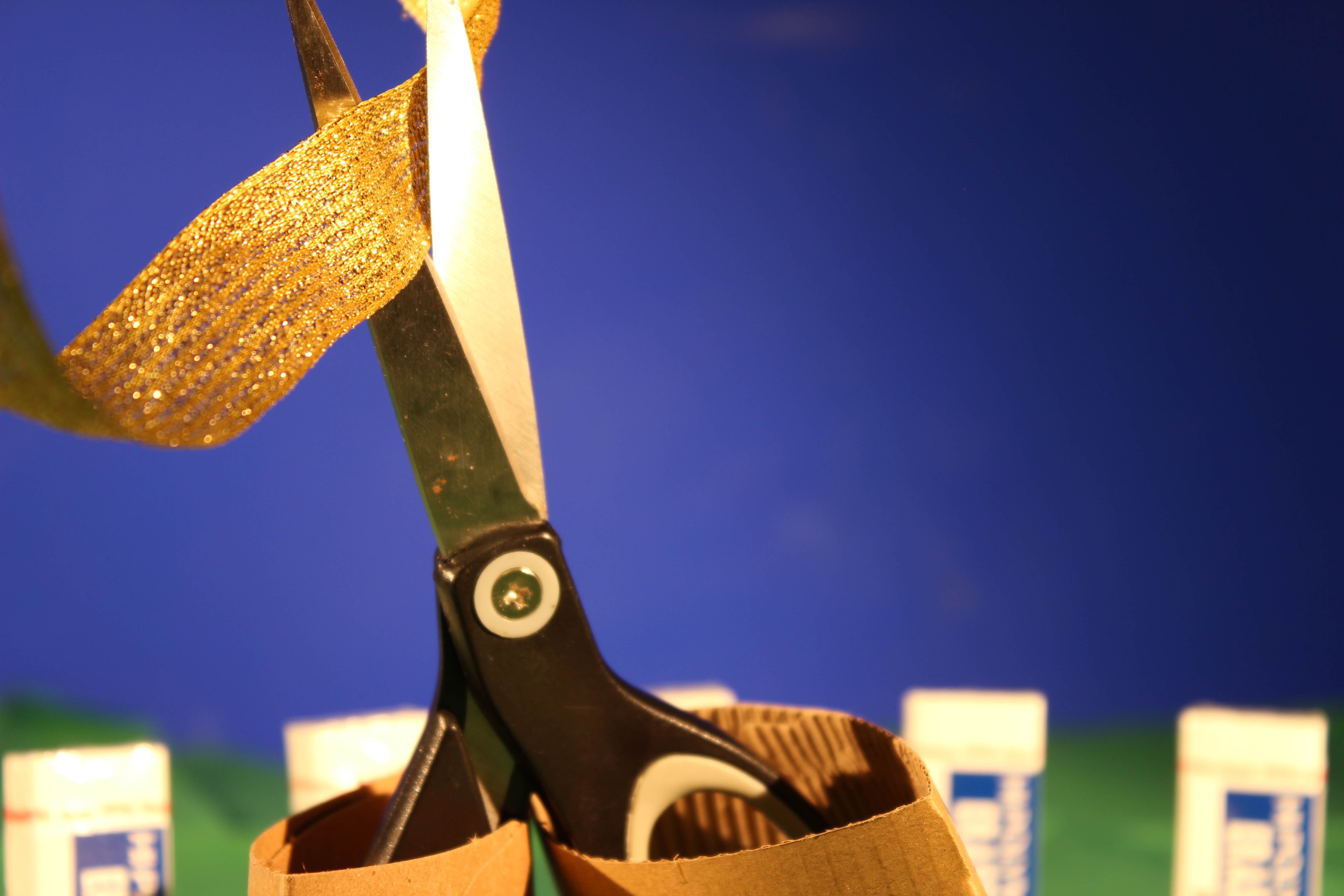 Photo of stop motion scissors cutting gold ribbon