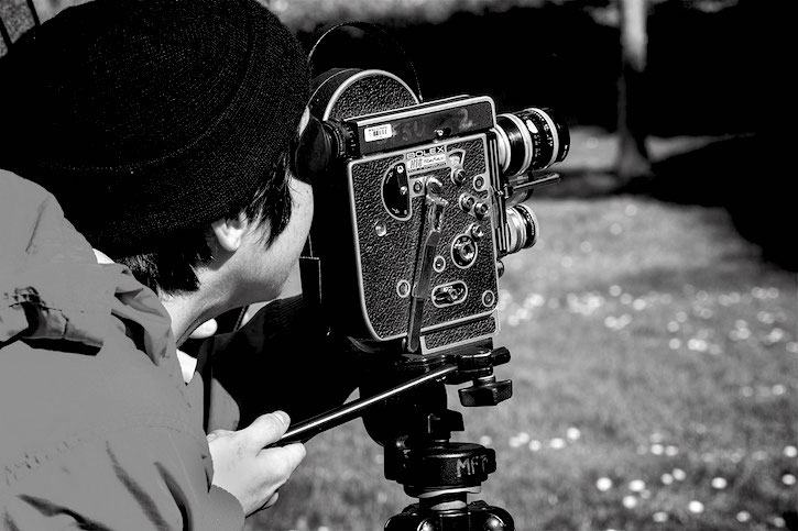 Student looking into film camera