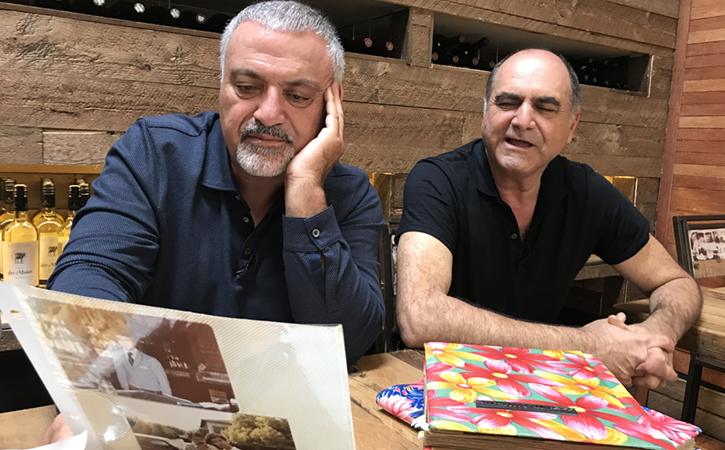 Two men at a table looking at art