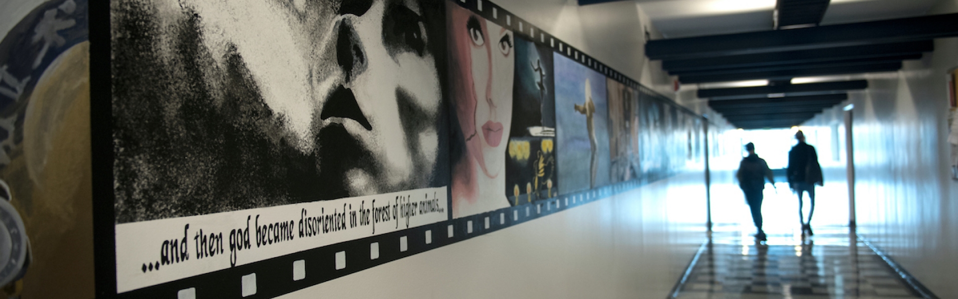 Film posters in hallway with silhouettes walking far away
